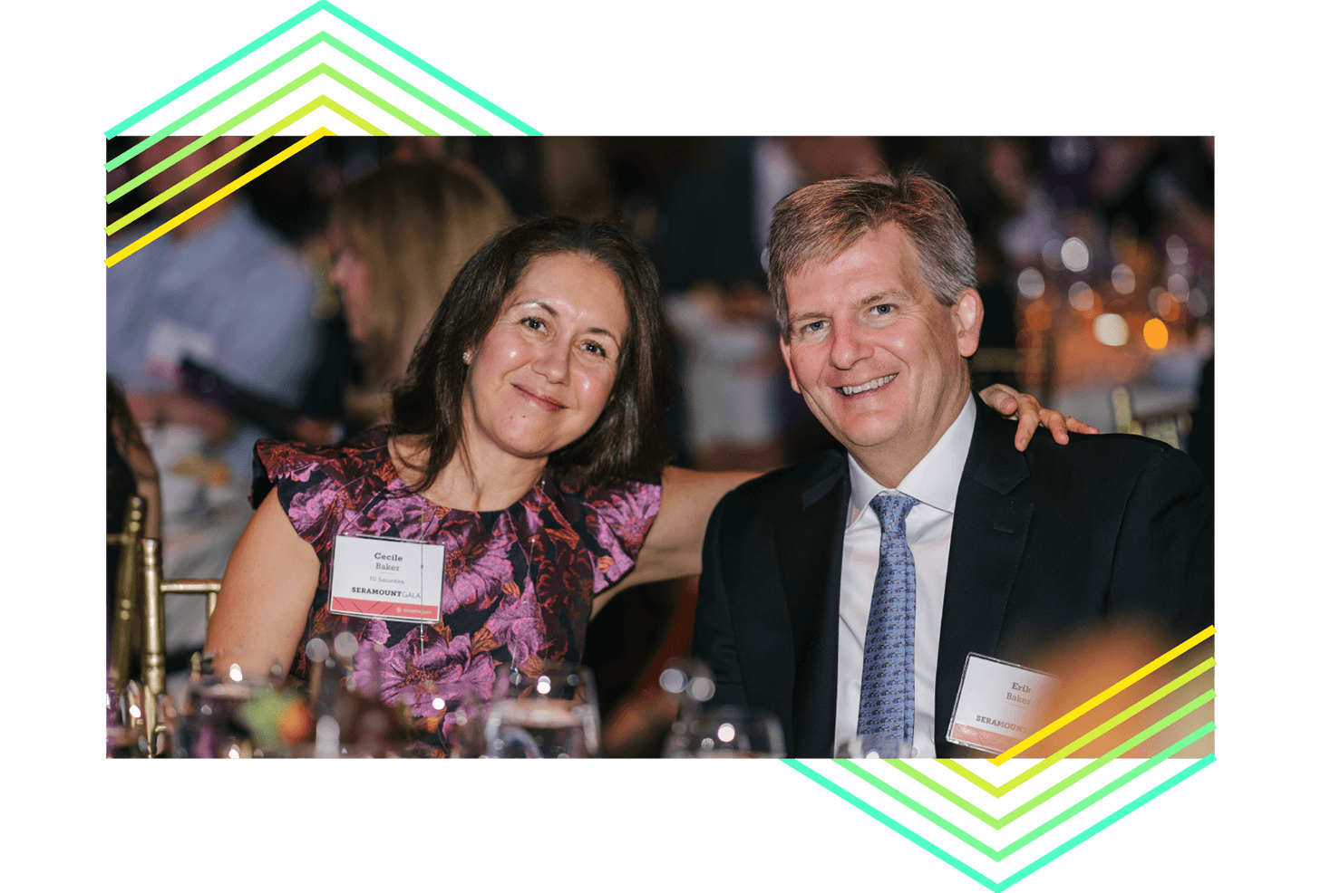 Two people sitting at a banquet table smiling