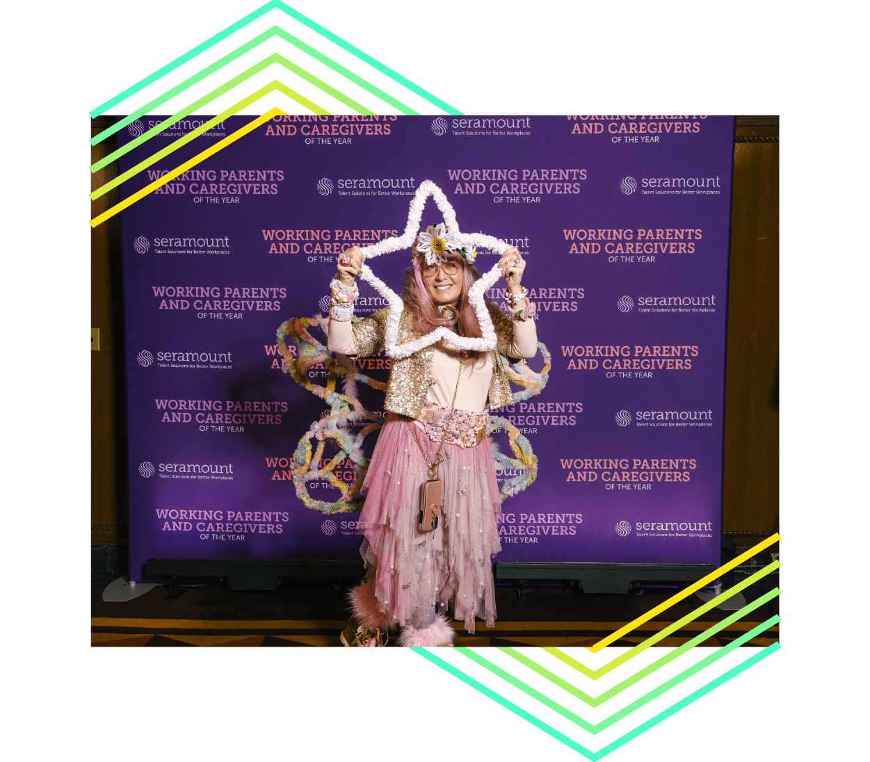 Gala vendor holding up craft art standing in front of a Seramount branded dark purple backdrop